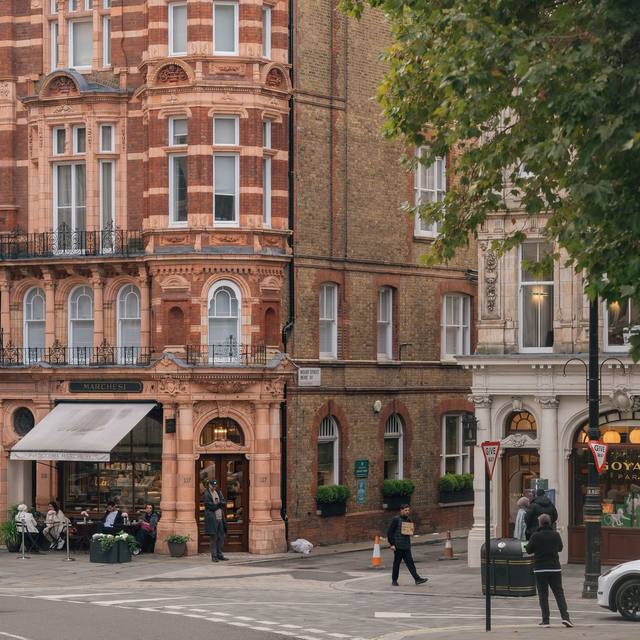 Red-brick corner building above a quiet mews junction