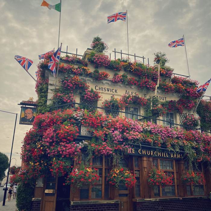 Flower-covered pub facade in full summer bloom