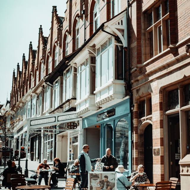 Pavement cafe tables outside ornate terrace shopfronts