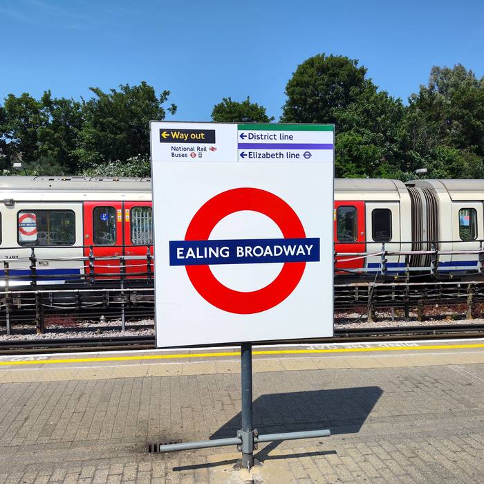 Underground roundel on the platform beside a waiting train