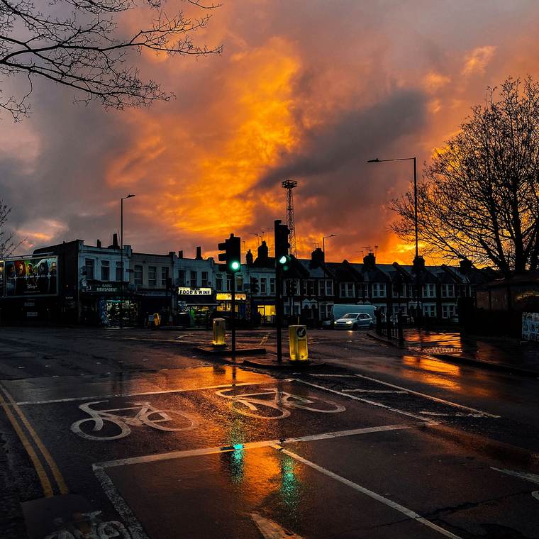 Fiery sunset over a wet road with cycle markings
