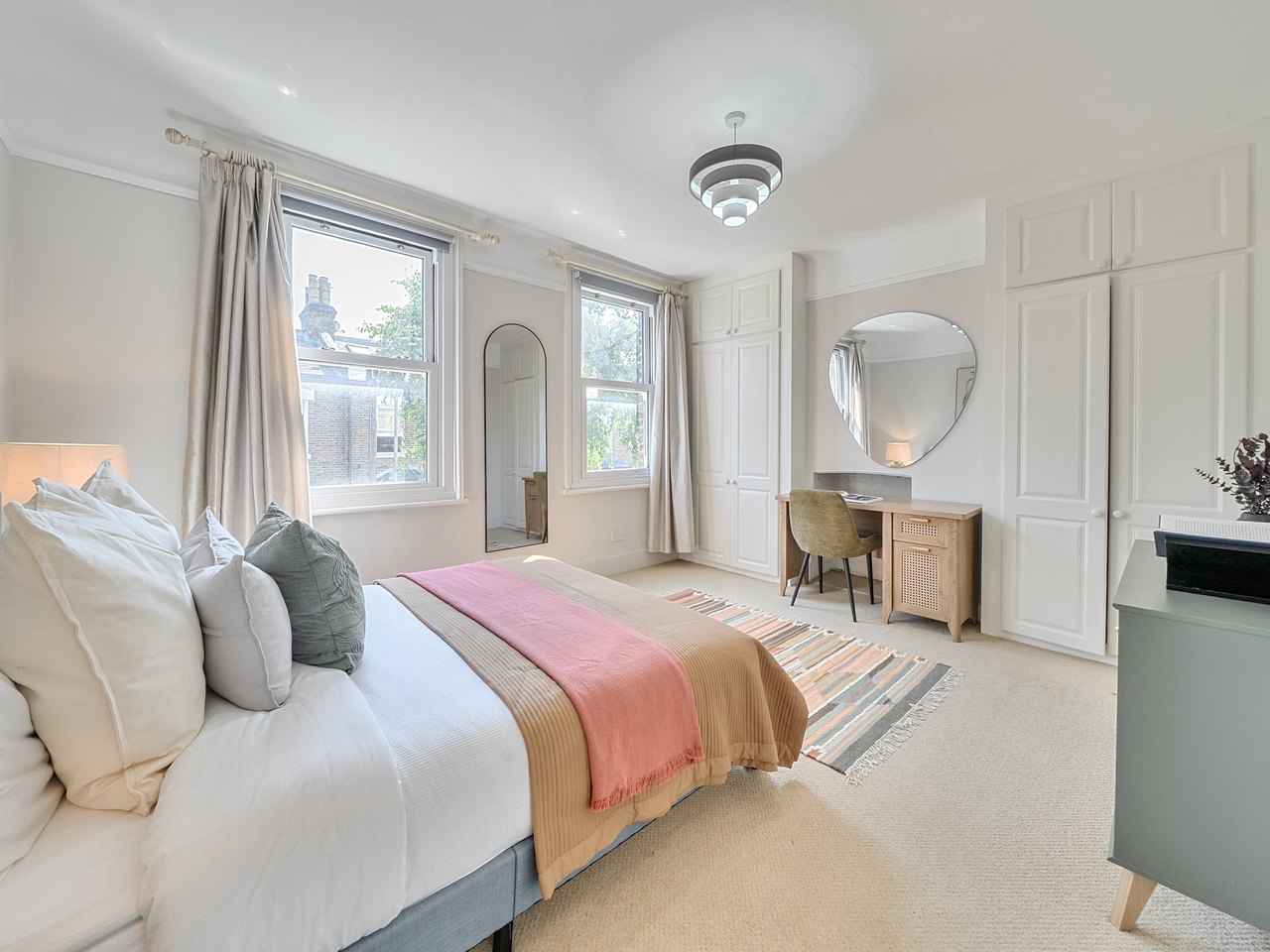 Double bedroom with two sash windows, fitted wardrobes and a desk
